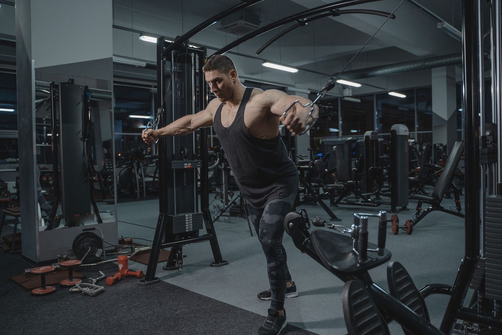 Man tränar bröst och bål med kabelhandtag på ett gym